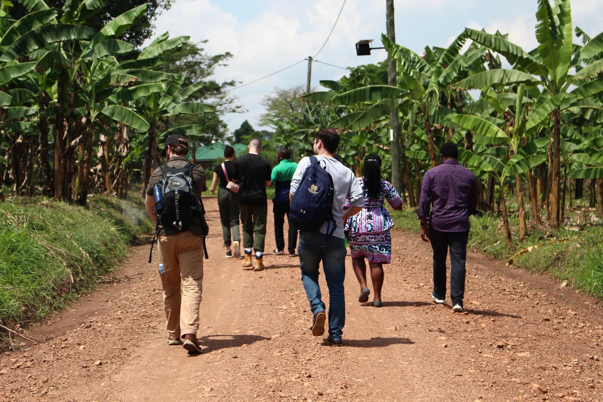 Reel Uganda trip, multiple of students are walking on dirt road