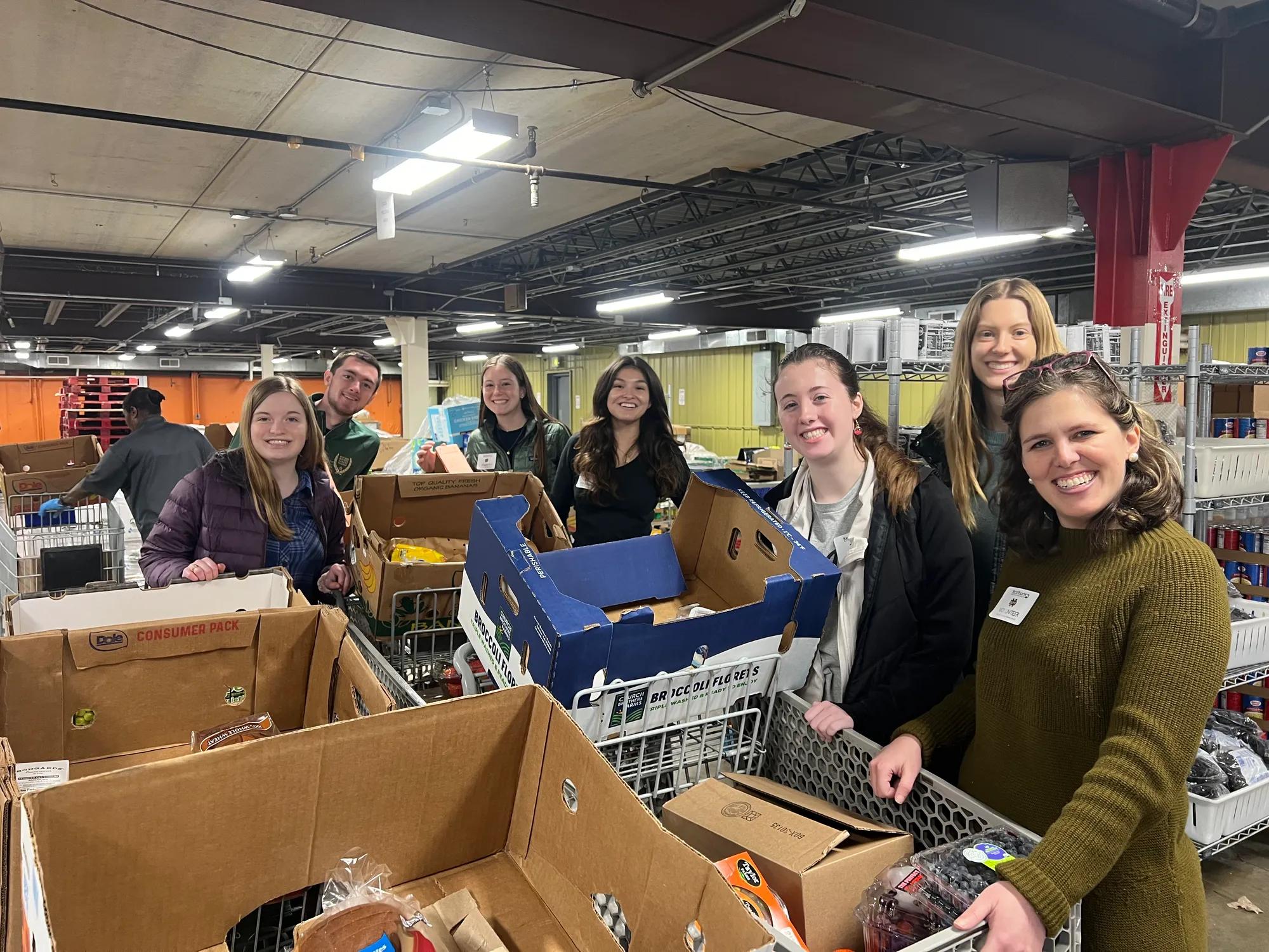 Service photo of 6 Business Honors students and Mentor Program Manager at the Indiana Food Bank.