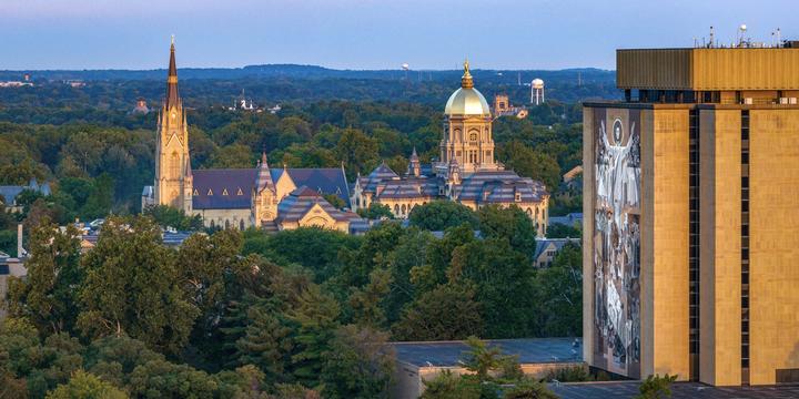 Aerial shot of campus with the library in the foreground and the main building and basilica in the background.